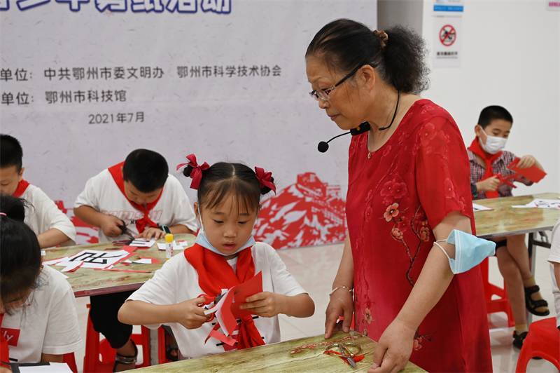 2021年7月10日，鄂州市科協(xié)組織落駕坪小學(xué)學(xué)生在鄂州市科技館開(kāi)展社會(huì)主義核心價(jià)值觀系列活動(dòng)，圖為開(kāi)展的紅色剪影圓夢(mèng)中華剪紙活動(dòng)，老師指導(dǎo)同學(xué)剪紙.jpg