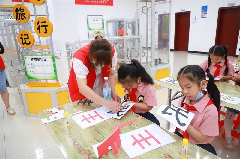 2021年7月10日，鄂州市科協(xié)組織落駕坪小學(xué)學(xué)生在鄂州市科技館開(kāi)展社會(huì)主義核心價(jià)值觀系列活動(dòng)，圖為開(kāi)展的紅色剪影圓夢(mèng)中華剪紙活動(dòng)，志愿者指導(dǎo)同學(xué)們.jpg
