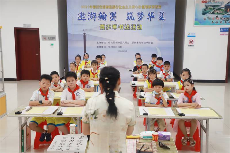 2021年7月10日，鄂州市科協(xié)組織蓮花小學(xué)學(xué)生在鄂州市科技館開展社會主義核心價值觀系列活動，圖為開展的遨游翰墨筑夢華夏書法活動，老師講解握筆姿勢2.jpg