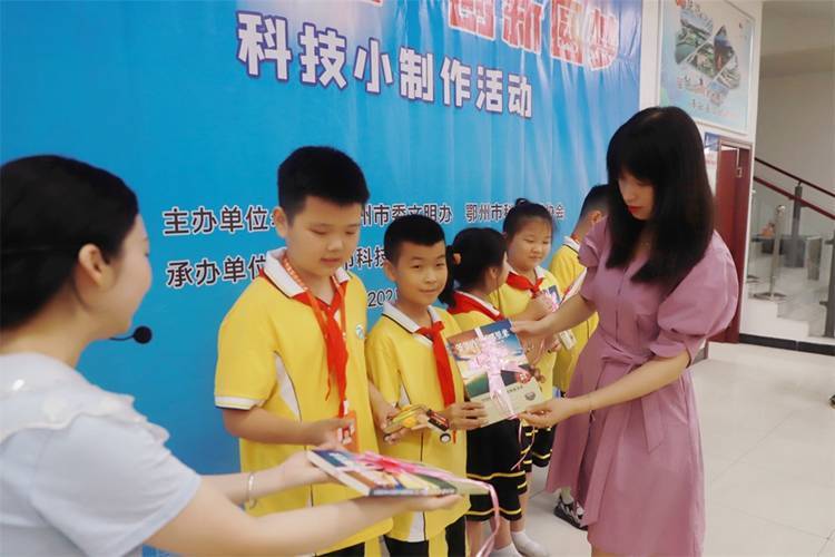 2021年7月9日鄂州市科協(xié)組織新民街小學(xué)學(xué)生在鄂州市科技館開展社會(huì)主義核心價(jià)值觀系列活動(dòng)，圖為開展的科技創(chuàng)新圓夢(mèng)中華科技小制作活動(dòng)，科協(xié)王雨濛部長正在為優(yōu)先制作完成的學(xué)生頒發(fā)獎(jiǎng)品.jpg